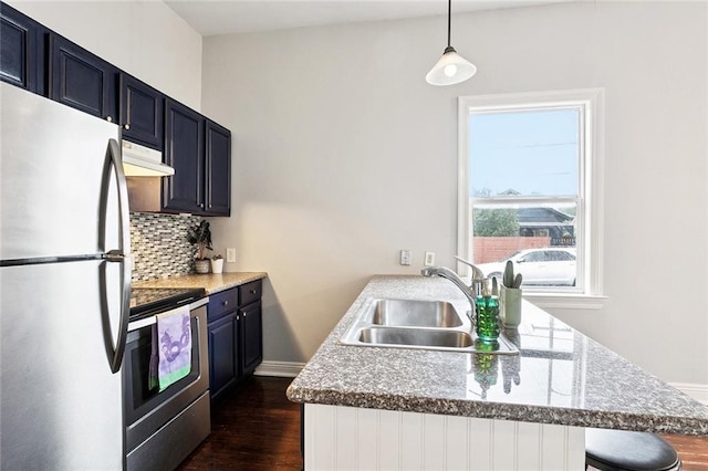 4528-30 Baudin St, New Orleans, LA 70119 - kitchen featuring stainless steel appliances, under cabinet range hood, tasteful backsplash, dark wood finished floors, and a breakfast bar area