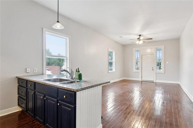 4528-30 Baudin St, New Orleans, LA 70119 - kitchen with ceiling fan, dark wood-style flooring, dark cabinets, hanging light fixtures, and a peninsula