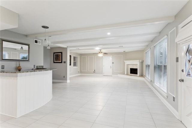 4480 Lennox Blvd, New Orleans, LA 70131 - unfurnished living room featuring beamed ceiling, a fireplace with raised hearth, a ceiling fan, and light tile patterned floors