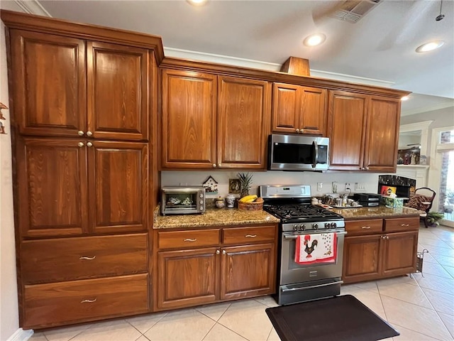 725 Marlene Dr, Gretna, LA 70056 - kitchen with stainless steel appliances, light tile patterned flooring, crown molding, dark stone counters, and brown cabinetry