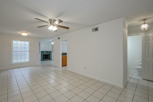 3320 Taft Park Unit C, Metairie, LA 70002 - unfurnished living room featuring ceiling fan, light tile patterned flooring, a fireplace, and ornamental molding