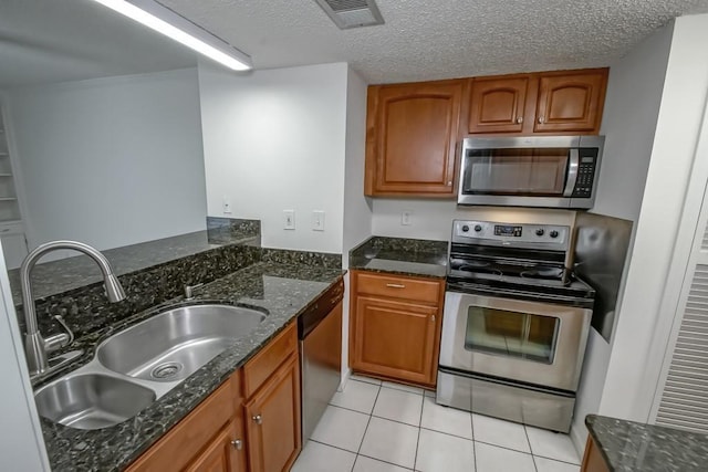 3320 Taft Park Unit C, Metairie, LA 70002 - kitchen with appliances with stainless steel finishes, brown cabinetry, light tile patterned flooring, and a textured ceiling