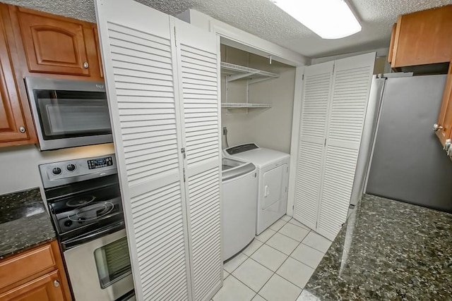 3320 Taft Park Unit C, Metairie, LA 70002 - washroom featuring washing machine and clothes dryer, a textured ceiling, and light tile patterned flooring