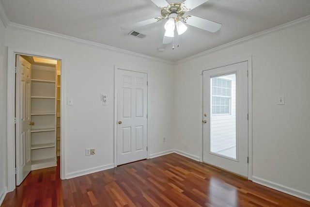3320 Taft Park Unit C, Metairie, LA 70002 - unfurnished bedroom featuring dark wood-style floors, multiple windows, a walk in closet, and crown molding