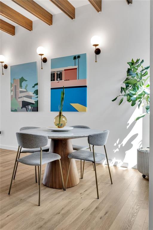 2113 Harmony St, New Orleans, LA 70115 - dining space with beam ceiling and light wood-style floors