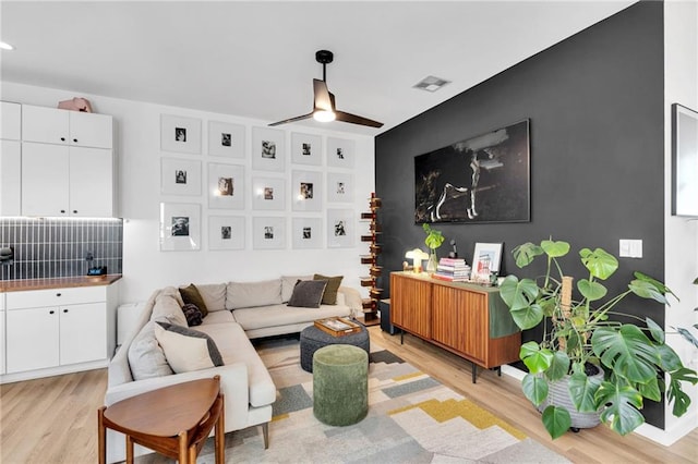 2113 Harmony St, New Orleans, LA 70115 - living area featuring light wood-style flooring and a ceiling fan