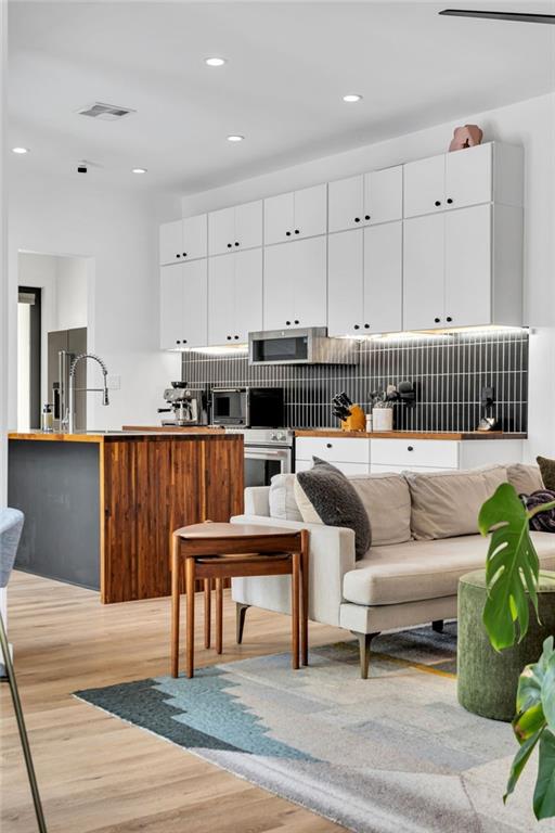 2113 Harmony St, New Orleans, LA 70115 - living area featuring light wood-type flooring and recessed lighting