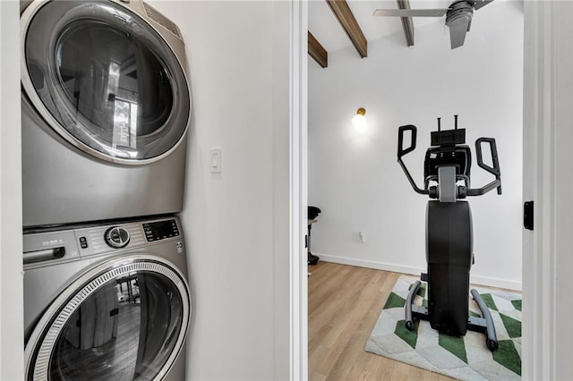 2113 Harmony St, New Orleans, LA 70115 - laundry room with stacked washing machine and dryer, wood finished floors, and ceiling fan