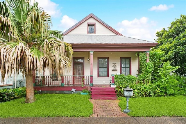 834 Madison St, Gretna, LA 70053 - view of front of property featuring covered porch, a front lawn, and a metal roof