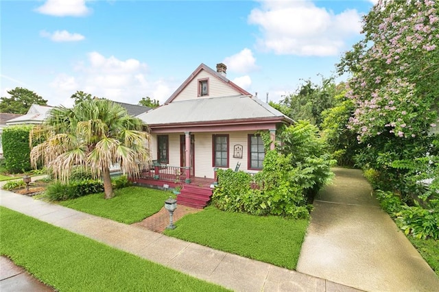 834 Madison St, Gretna, LA 70053 - view of front of home with a porch, a front yard, and a chimney