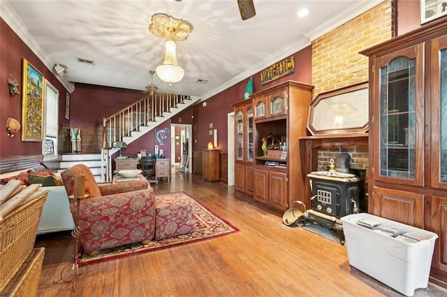 834 Madison St, Gretna, LA 70053 - living area featuring stairs, a wood stove, hardwood / wood-style flooring, and ornamental molding