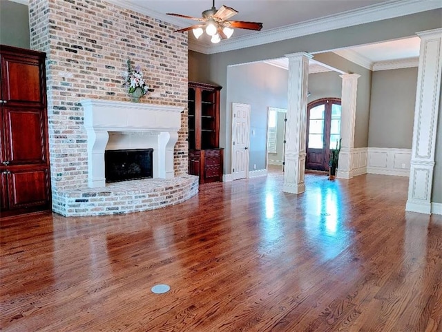 11 Mark Smith Dr, Mandeville, LA 70471 - unfurnished living room with wood finished floors, ornate columns, a ceiling fan, crown molding, and a fireplace