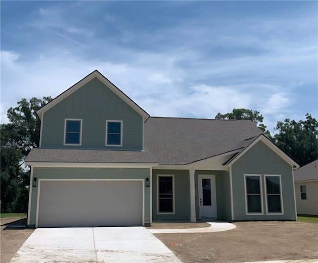 901 Dandelion Dr, Waggaman, LA 70094 - view of front of house featuring board and batten siding, driveway, a garage, and roof with shingles