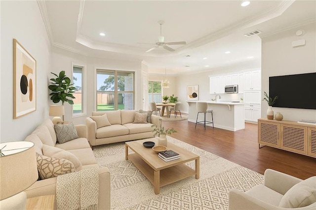 1217 N Starrett Rd, Metairie, LA 70003 - living area featuring ornamental molding, plenty of natural light, wood finished floors, a tray ceiling, and ceiling fan