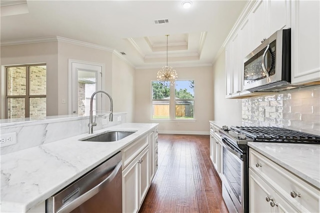1217 N Starrett Rd, Metairie, LA 70003 - kitchen featuring stainless steel appliances, dark wood finished floors, a raised ceiling, white cabinets, and light stone counters