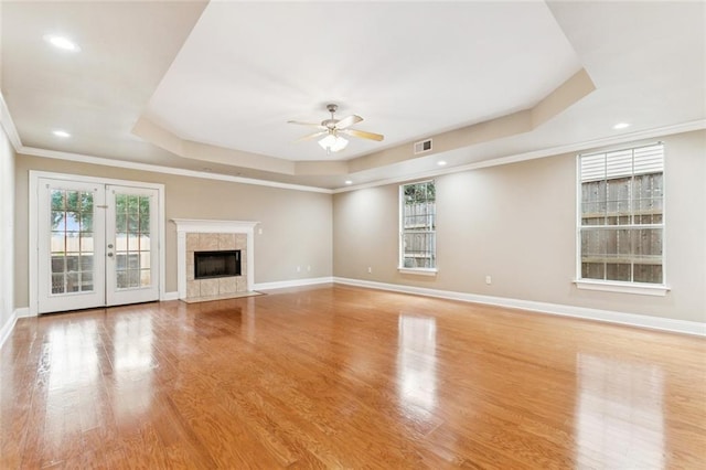 4339 Anthony St, Metairie, LA 70001 - unfurnished living room with a raised ceiling, ceiling fan, light wood-style flooring, recessed lighting, and a tiled fireplace