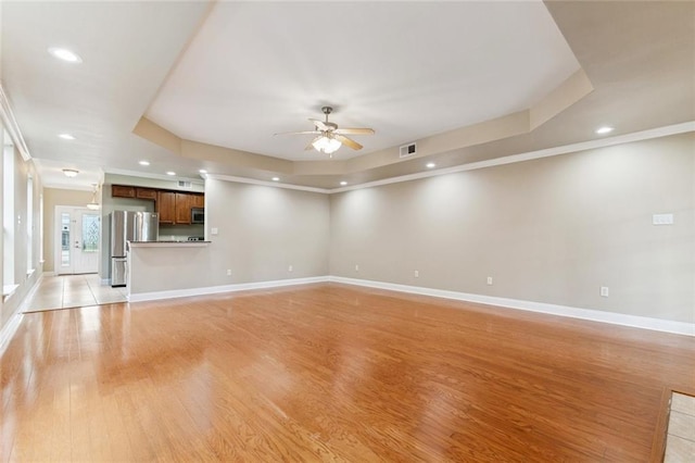 4339 Anthony St, Metairie, LA 70001 - unfurnished living room with a tray ceiling, light wood-type flooring, a ceiling fan, recessed lighting, and crown molding