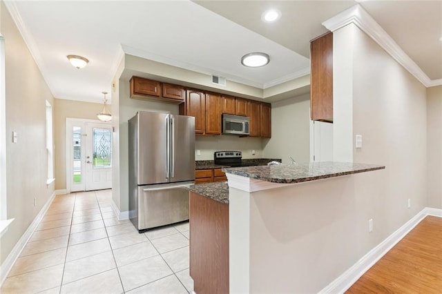 4339 Anthony St, Metairie, LA 70001 - kitchen with appliances with stainless steel finishes, ornamental molding, a peninsula, dark stone counters, and brown cabinetry