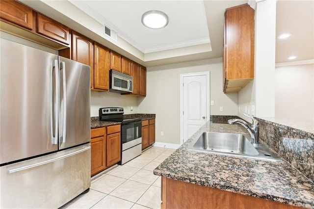 4339 Anthony St, Metairie, LA 70001 - kitchen featuring appliances with stainless steel finishes, brown cabinetry, light tile patterned floors, ornamental molding, and a raised ceiling