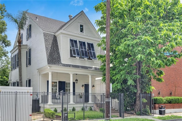 5349 Prytania St, New Orleans, LA 70115 - view of front facade with a shingled roof, covered porch, a gate, and a fenced front yard