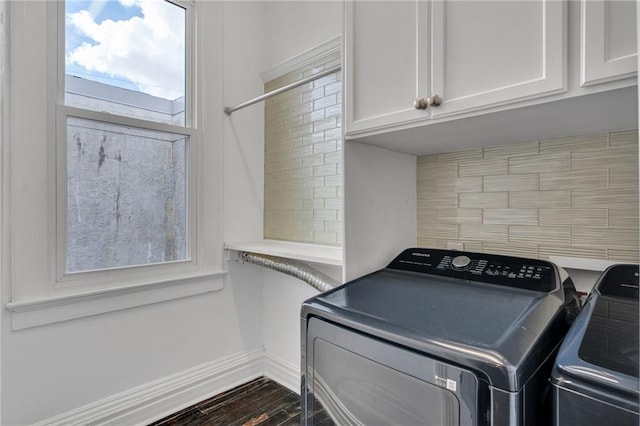 5349 Prytania St, New Orleans, LA 70115 - laundry area featuring cabinet space, washing machine and clothes dryer, dark wood-style floors, and healthy amount of natural light