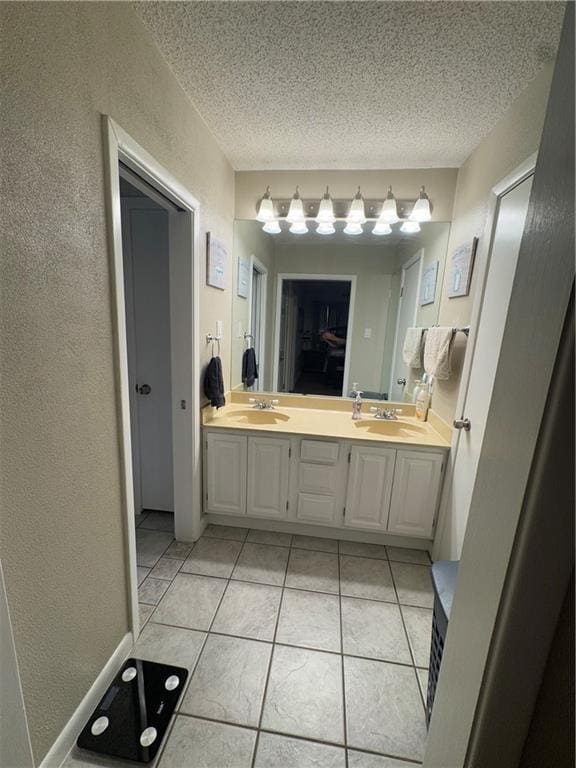 1620 Kent Ave, Metairie, LA 70001 - bathroom with tile patterned floors, double vanity, a textured wall, and a textured ceiling
