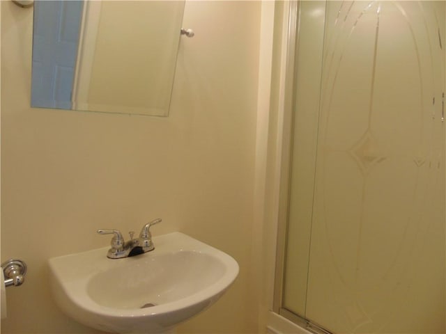 bathroom featuring walk in shower and sink