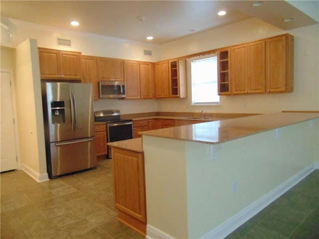 kitchen featuring light tile floors, appliances with stainless steel finishes, kitchen peninsula, and sink