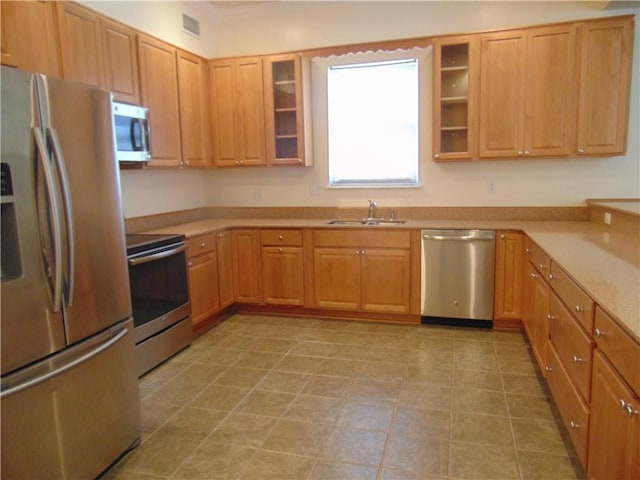 kitchen with light tile floors, appliances with stainless steel finishes, and sink