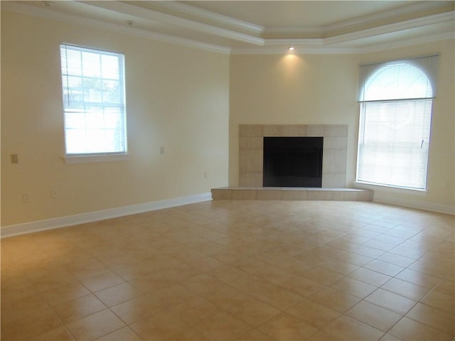 unfurnished living room featuring a raised ceiling, a fireplace, and light tile floors