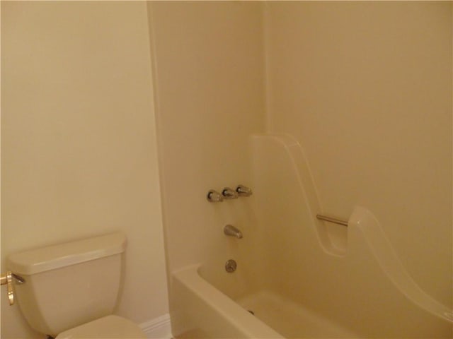 bathroom with toilet and bathing tub / shower combination