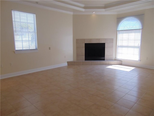 unfurnished living room with light tile floors, a tray ceiling, a healthy amount of sunlight, and a fireplace