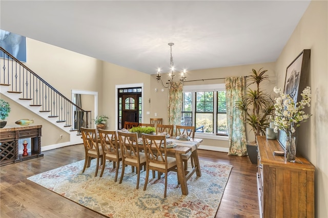 dining room featuring baseboards, a notable chandelier, stairway, and dark wood-type flooring