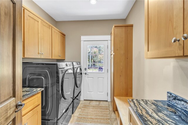 laundry area with cabinet space, light tile patterned floors, and independent washer and dryer