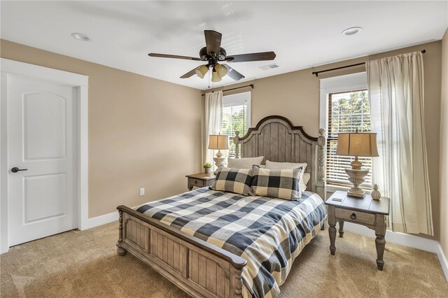 bedroom with visible vents, ceiling fan, light carpet, and baseboards