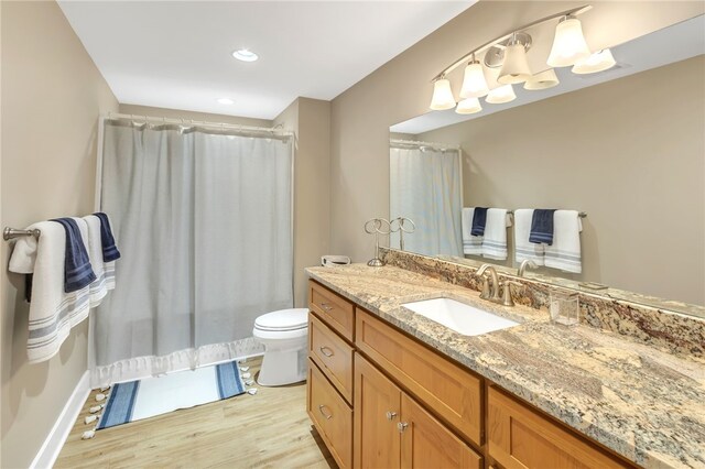 full bath with a shower with shower curtain, vanity, toilet, and wood finished floors