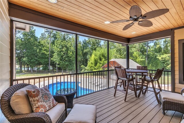 sunroom featuring a ceiling fan and wood ceiling