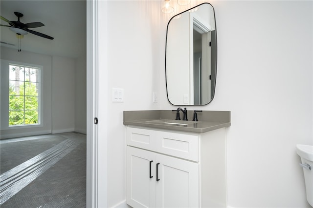 bathroom with toilet, ceiling fan, and vanity