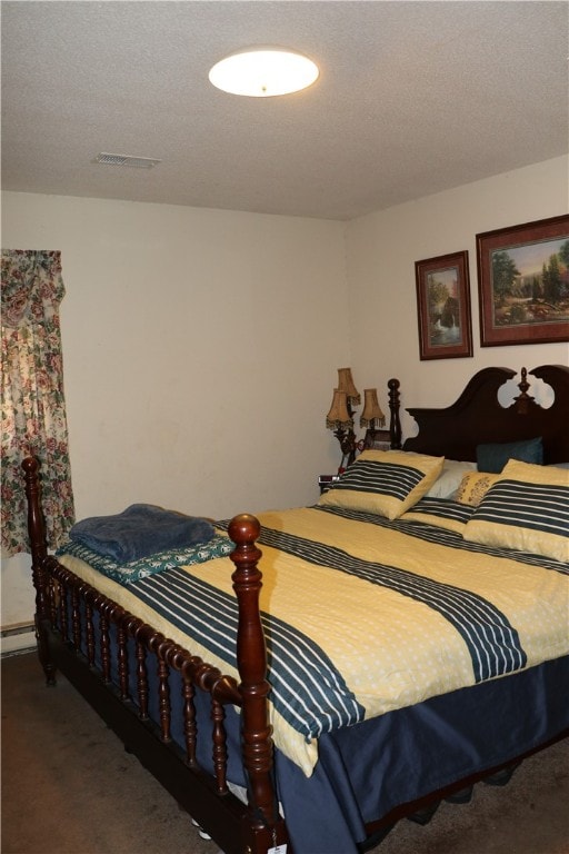 bedroom with dark colored carpet, a textured ceiling, and baseboard heating