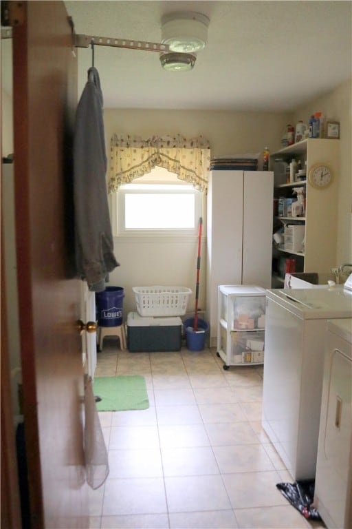 laundry room featuring separate washer and dryer and light tile patterned floors