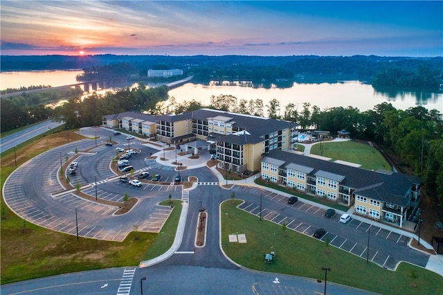 aerial view at dusk featuring a water view