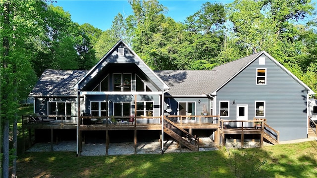 rear view of property featuring a deck and a yard