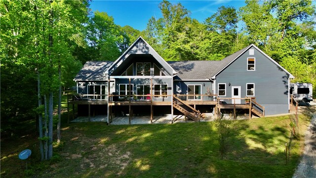 back of property featuring a wooden deck and a yard