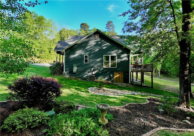 view of home's exterior with a deck and a lawn