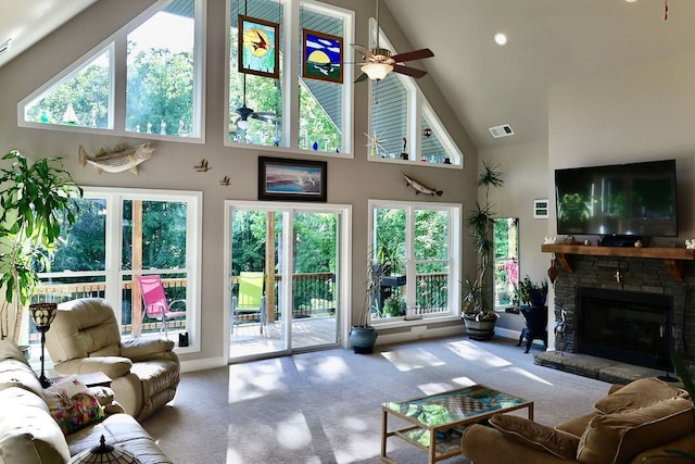 carpeted living room with ceiling fan, a fireplace, high vaulted ceiling, and a wealth of natural light