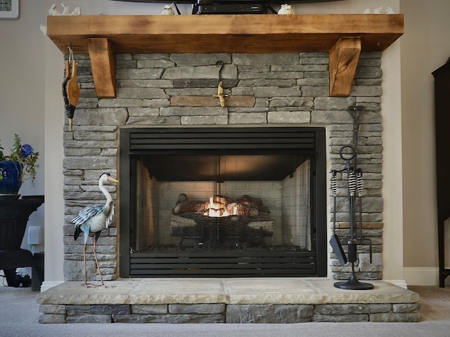 interior details featuring carpet and a stone fireplace