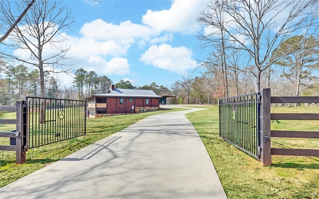 view of gate with a lawn