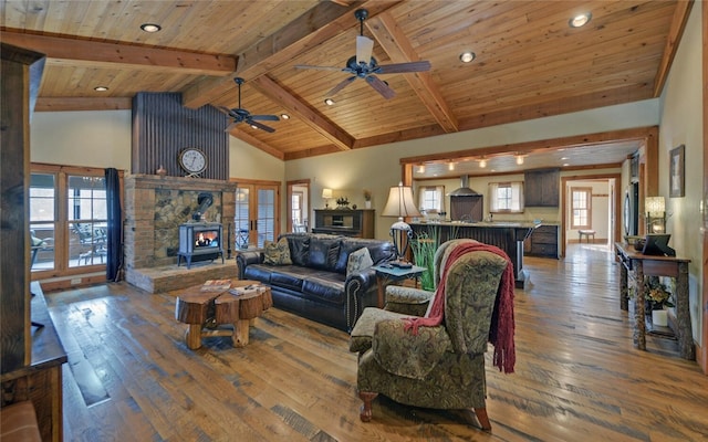 living room featuring wooden ceiling, beam ceiling, dark hardwood / wood-style floors, and a wood stove