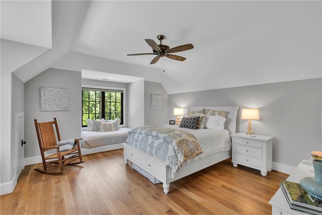 bedroom with ceiling fan, vaulted ceiling, and light hardwood / wood-style floors