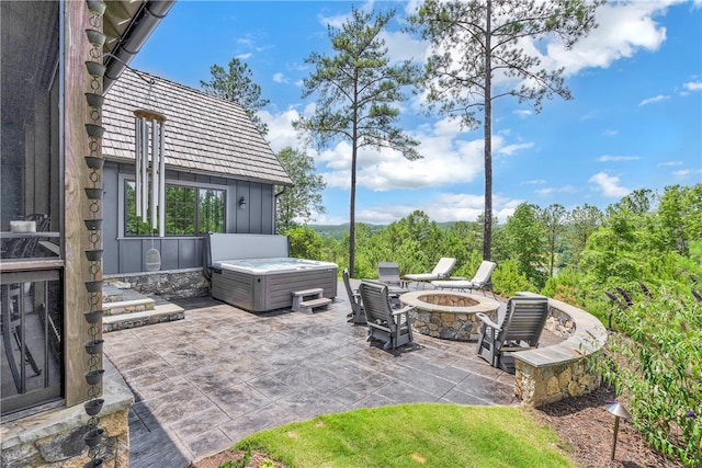 view of patio / terrace featuring a hot tub and a fire pit